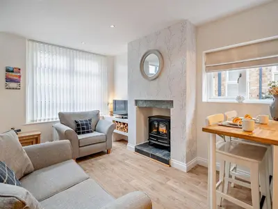 a living room with a fireplace and a table at 1 Bed in Keswick 96314 in Keswick