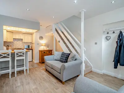 a living room with a couch and a kitchen at 1 Bed in Keswick 96314 in Keswick