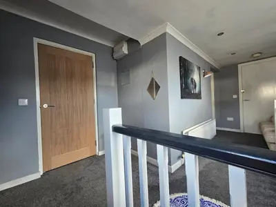 a room with a staircase with a wooden door at Lakes Cottage Beckermet in Beckermet
