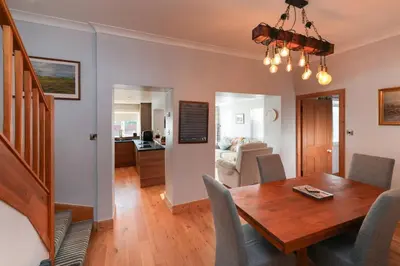 a dining room and living room with a table and chairs at Seabreeze in Prestwick in Prestwick