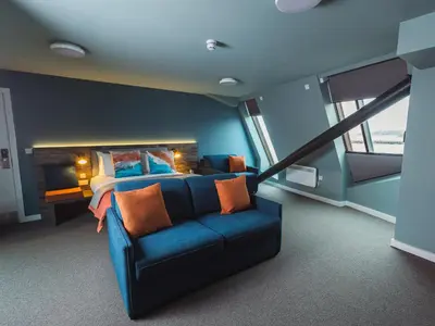 a bedroom with a blue couch and a bed at The Edge in Whitehaven