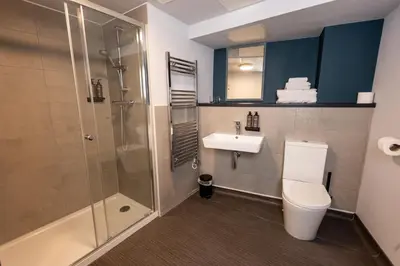a bathroom with a shower and a toilet and a sink at The Edge in Whitehaven