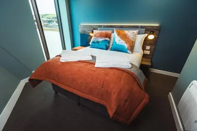 a bedroom with a bed with pillows and a window at The Edge in Whitehaven