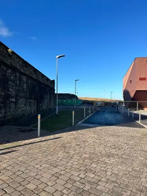 a cobblestone street next to a brick wall at The Edge in Whitehaven