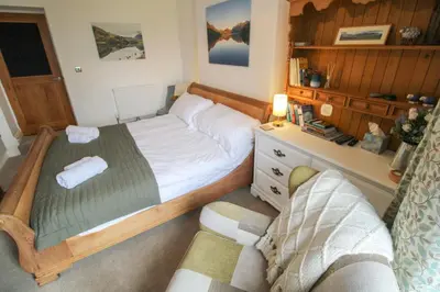 a small bedroom with a bed and a couch at Lorton View, nestles on the fellside with walks from the door close to Lorton in Lorton
