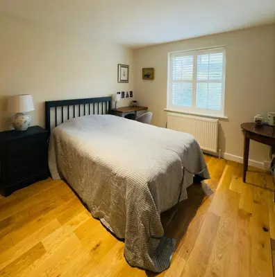 a bedroom with a bed and a desk and a window at Stylish Two-Bedroom Flat with Garden Near Henley Town Centre in Moffat