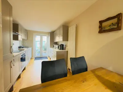 a kitchen with a table and two chairs and a kitchen with a table at Stylish Two-Bedroom Flat with Garden Near Henley Town Centre in Moffat