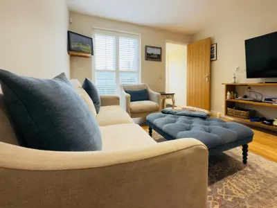 a living room with a couch and a tv at Stylish Two-Bedroom Flat with Garden Near Henley Town Centre in Moffat