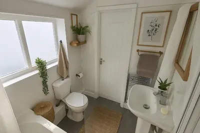 a white bathroom with a toilet and a sink at Armstrong St - Cosy 3 Bedroom Home in Workington
