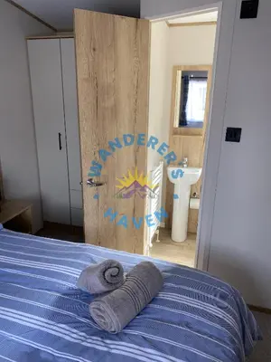 a bedroom with a bed with towels on it at Wanderers Haven, Brigham, Cockermouth, Cumbria in Brigham
