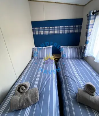 a bedroom with two twin beds with towels at Wanderers Haven, Brigham, Cockermouth, Cumbria in Brigham