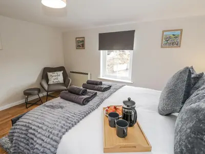 a bedroom with a bed with a tray on it at Daisy Cottage in Wigton