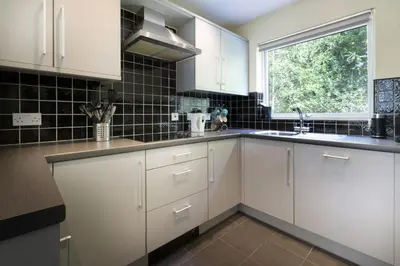 a kitchen with white cabinets and a window at 22 Thrang Brow - Langdale Valley in Chapel Stile
