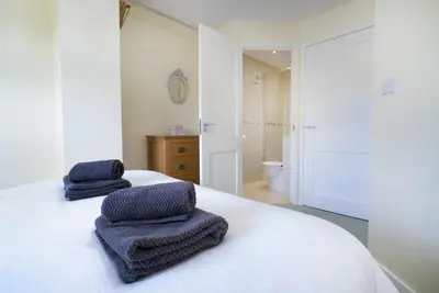 a white bedroom with two towels on a bed at 22 Thrang Brow - Langdale Valley in Chapel Stile