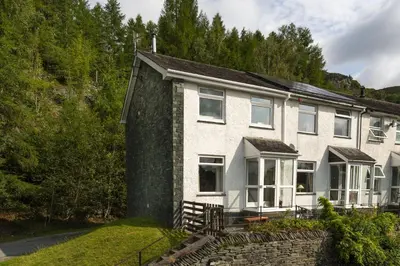 a large white house with a stone wall at 22 Thrang Brow - Langdale Valley in Chapel Stile