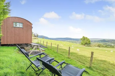 a group of chairs sitting in the grass next to a building at 1 Bed in Keswick oc-f33118 in Bassenthwaite