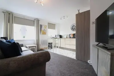a living room with a couch and a kitchen at Cosy 1 bed flat in central Ayr in Ayr