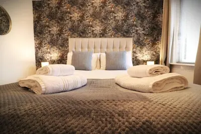 a bedroom with a large bed with towels on it at Cosy 1 bed flat in central Ayr in Ayr