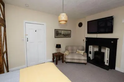 a bedroom with a bed and a fireplace and a tv at Troon - Coastal Getaway in Troon