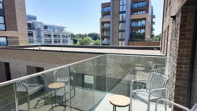 a balcony with chairs and tables on a building at The Sunrise Den, Modern 2-Bed Apartment, Free Parking in Yarrow
