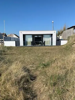 a house on a hill with a grass field at The Beach House in Moffat