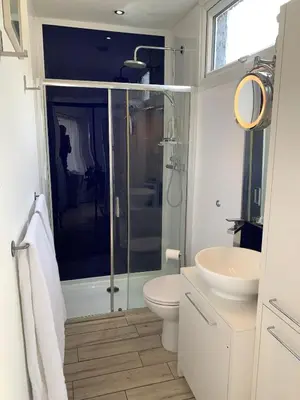 a bathroom with a shower and a toilet and a sink at The Beach House in Moffat