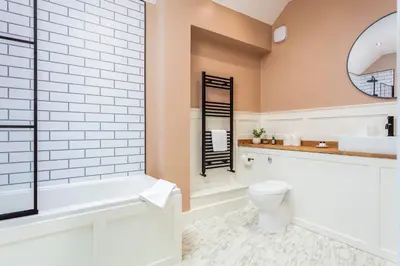 a bathroom with a tub and a toilet and a sink at Weaver Suite - Donnini Apartments in Ayr