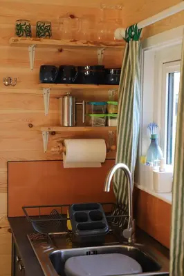 a kitchen with a sink and a counter top at Burnside of Ae Glamping Shepherd's Hut in Dumfries