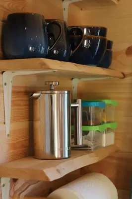a shelf with a tea pot and cups on it at Burnside of Ae Glamping Shepherd's Hut in Dumfries