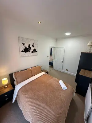 a bedroom with a large bed in a room at Fairholme Gardens House in Moffat