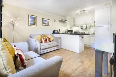 a living room with two couches and a kitchen at The Screes Apartment - Short stroll from Wastwater - Herdwick Cottages