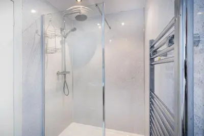 a shower with a glass door in a bathroom at The Screes Apartment - Short stroll from Wastwater - Herdwick Cottages