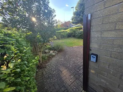 a brick walkway leading into a garden with a door at Lovely 3 Bedroom House 5 Minutes M6 or Carlisle in Carlisle