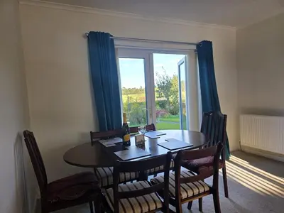 a dining room with a table and chairs and a window at Lovely 3 Bedroom House 5 Minutes M6 or Carlisle in Carlisle