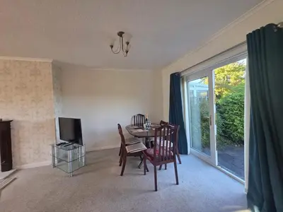 a living room with a table and chairs and a television at Lovely 3 Bedroom House 5 Minutes M6 or Carlisle in Carlisle