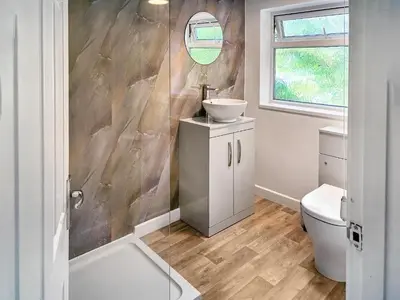 a bathroom with a sink and a toilet and a mirror at Revita in Egremont