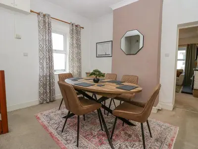 a dining room with a wooden table and chairs at Cosy Cottage in Cumbria, West of Lake District in Broughton Moor