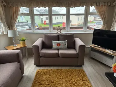 a living room with a couch and a television at Cosy Caravan by the sea in Cairnryan