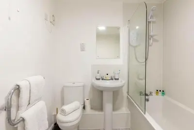a bathroom with a toilet and a sink and a shower at Fabulous 1 Bed Harbour-side Apartment with Balcony in Whitehaven