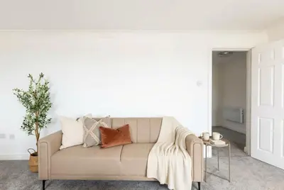 a living room with a couch with pillows on it at Fabulous 1 Bed Harbour-side Apartment with Balcony in Whitehaven