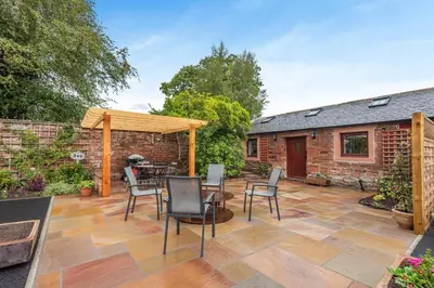 a patio with a table and chairs and a brick building at 1 Bed in Wetheral oc-r32933 in Wreay