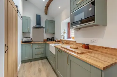 a kitchen with green cabinets and a wooden counter top at 1 Bed in Wetheral oc-r32933 in Wreay