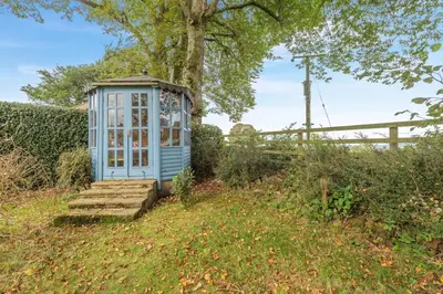 a small greenhouse in a garden with a tree at 4 Bed in Ellonby oc-y33284 in Ellonby