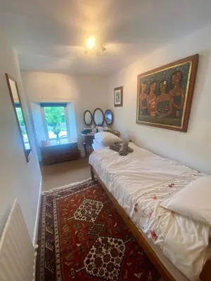 a bedroom with a bed and a painting on the wall at School House in Patterdale