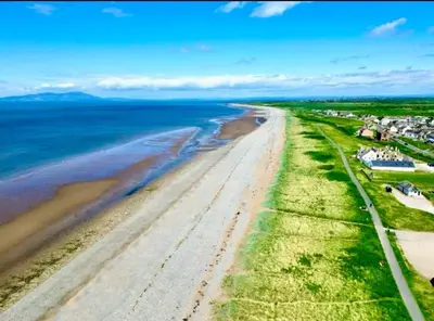 an aerial view of a beach with houses and the ocean at Old Post Office By The Sea in Allonby