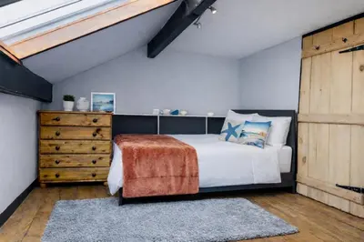 a bedroom with a bed and a wooden dresser at Old Post Office By The Sea in Allonby