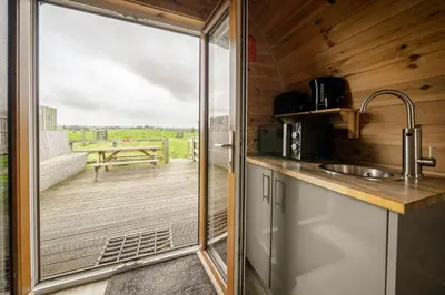a kitchen with a sliding glass door leading to a deck at Unit 3 - High Pike View Camping Pod in Carlisle