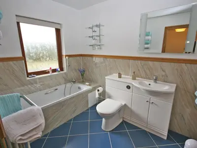 a bathroom with a tub and a toilet and a sink at Laggansally Lodge in Leswalt