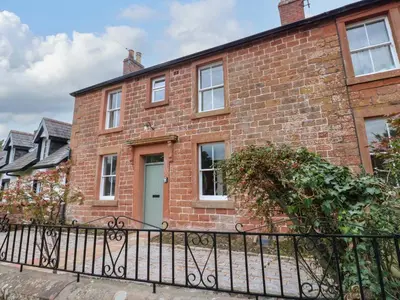 a brick house with a black iron fence at Milford in Carlisle