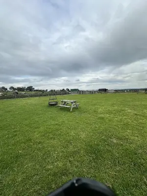 a picnic table in the middle of a field at Unit 0 - Fully Serviced All Weather Pitch with Hot Tub in Carlisle